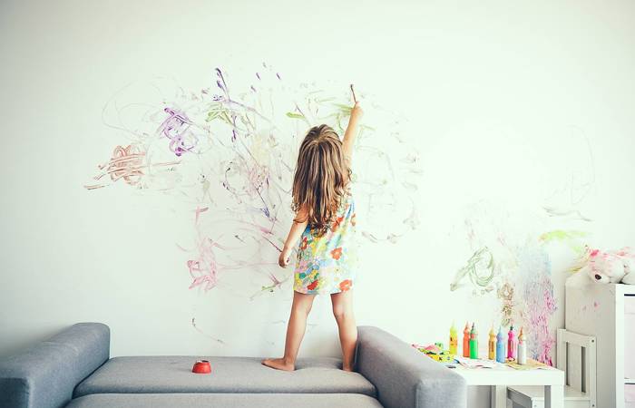 Little girl painting a wall