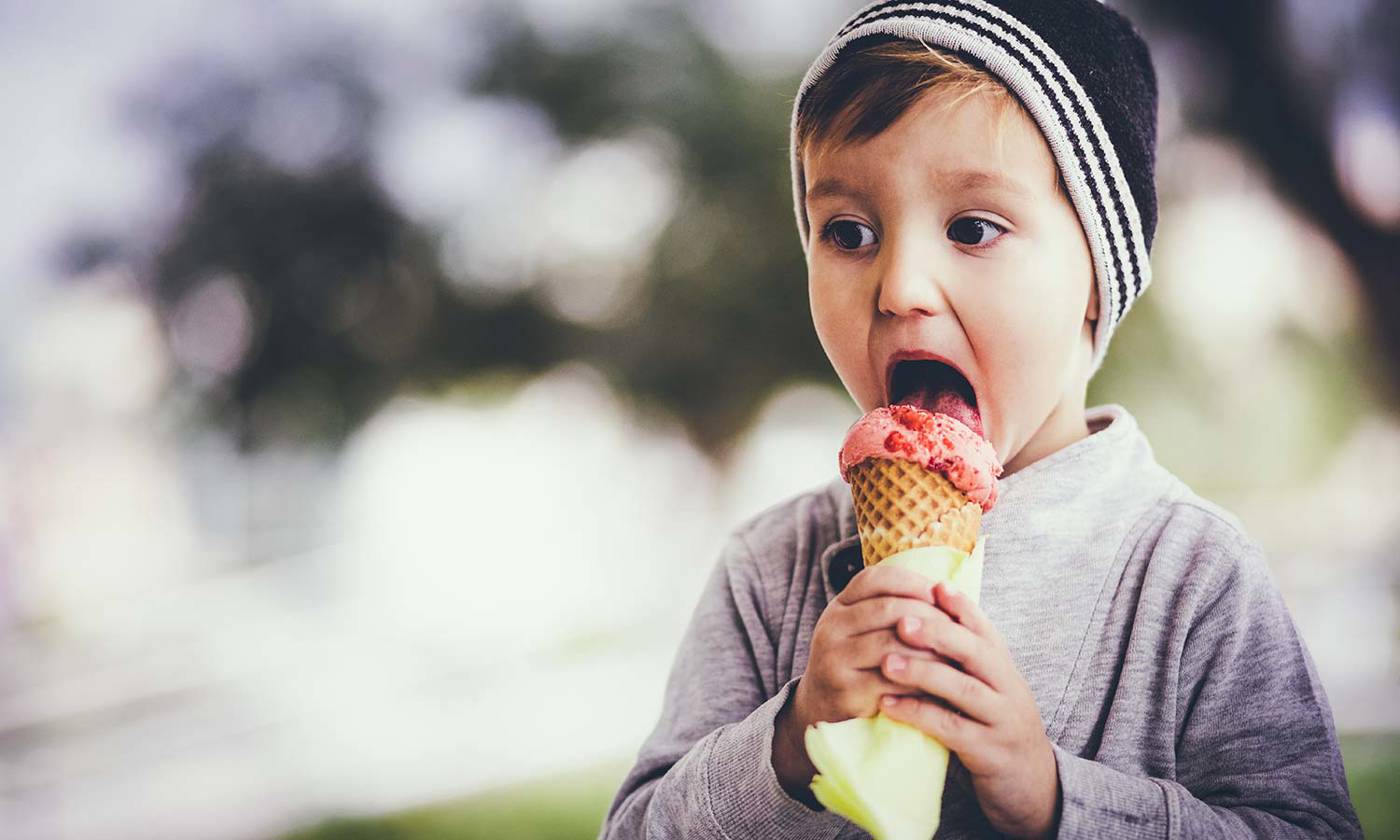 Young blond boy eating ice cream