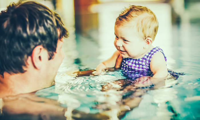 Father swimming with baby girl