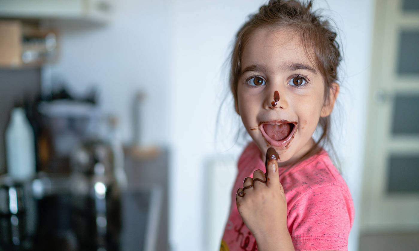 Girl eating chocolate with her finger