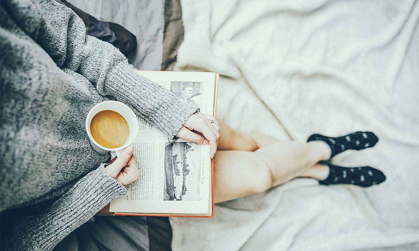 Woman having coffee and reading a book