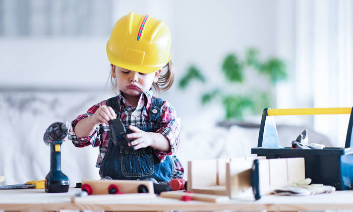 Litte girl playing at being a carpenter