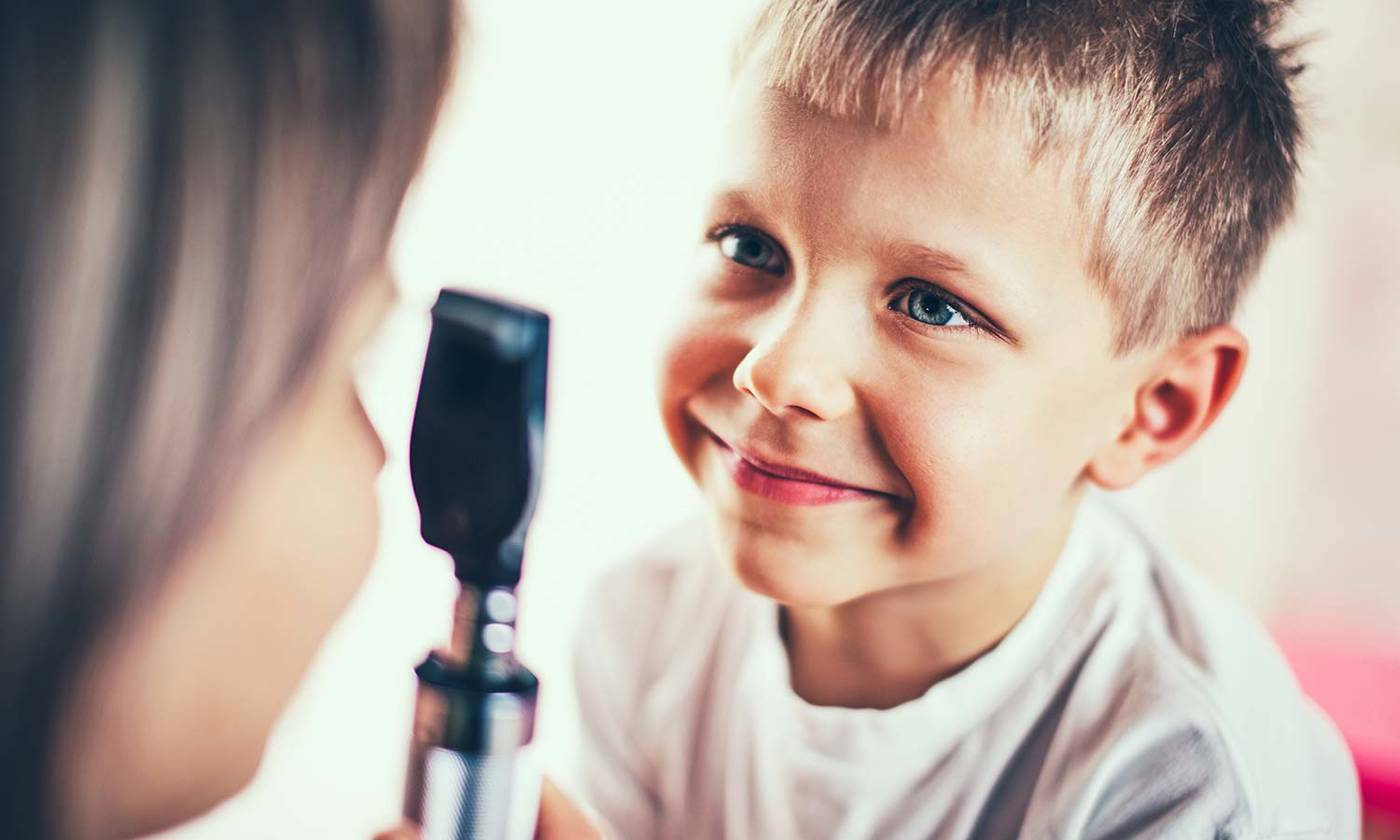 Doctor is examining eyes of the little boy