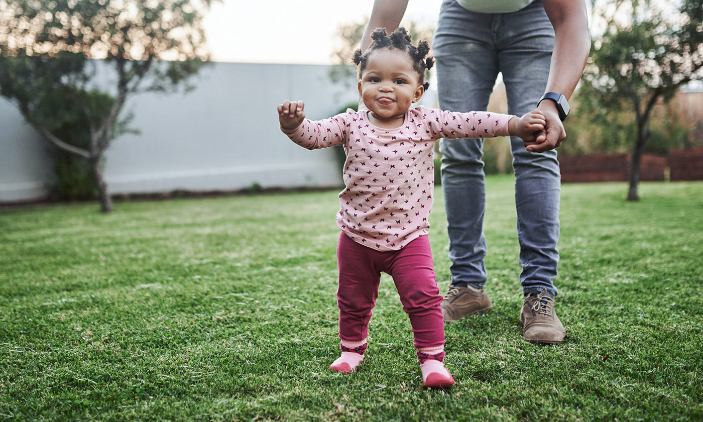 Baby girl having fun with her dad in their backyard
