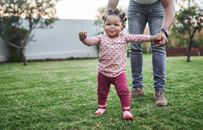 Baby girl having fun with her dad in their backyard