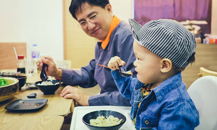 Toddler eating food with fork and spoon