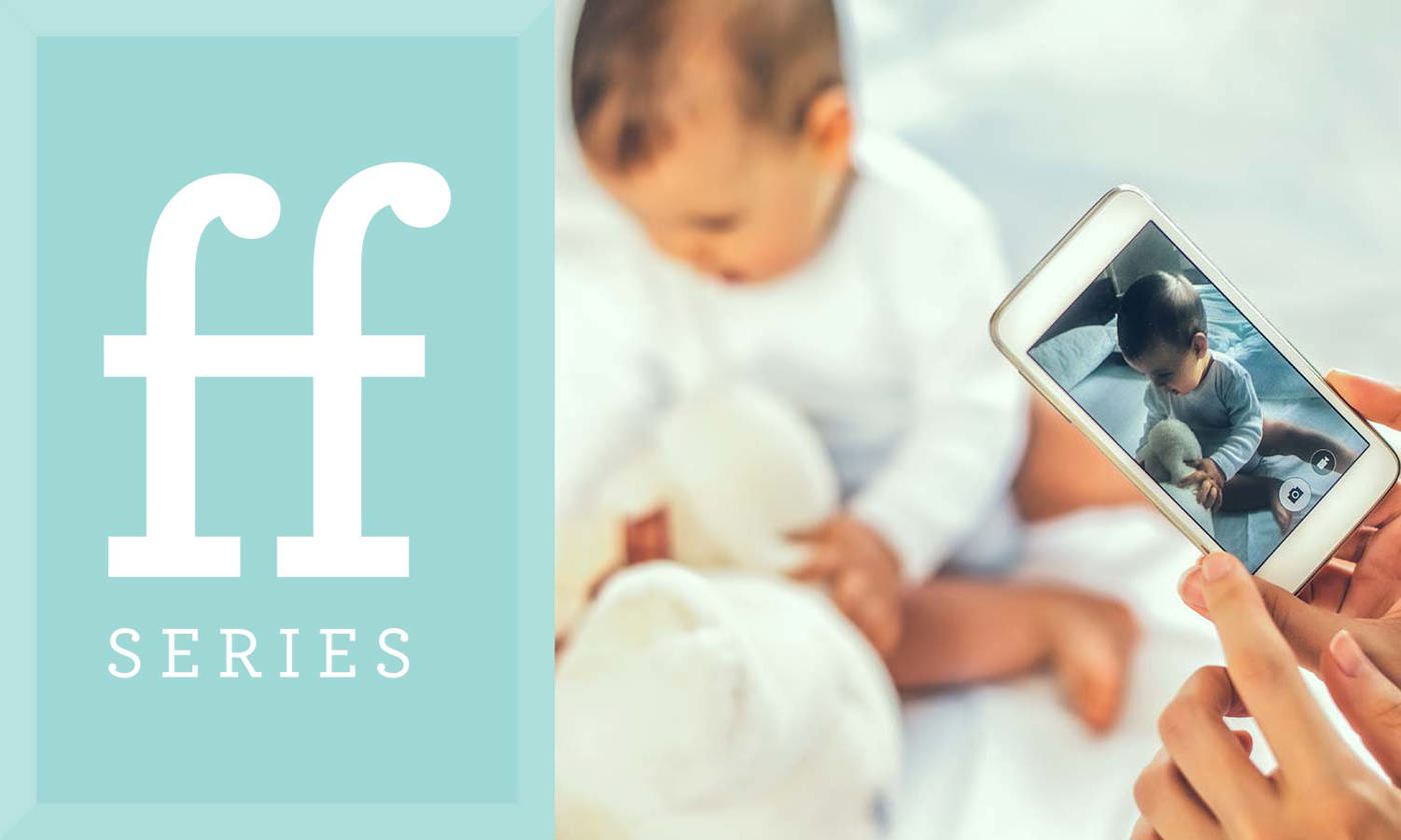 Mother taking photograph of infant