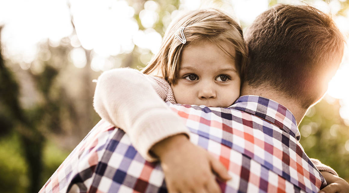 Young girl being consoled by her father