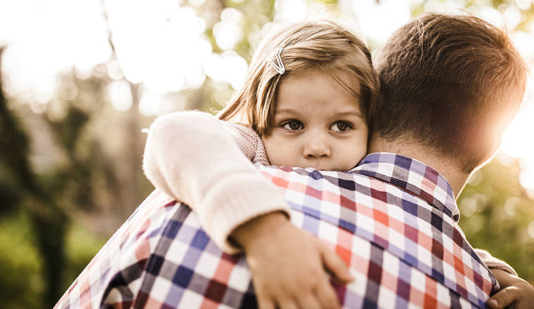 Young girl being consoled by her father