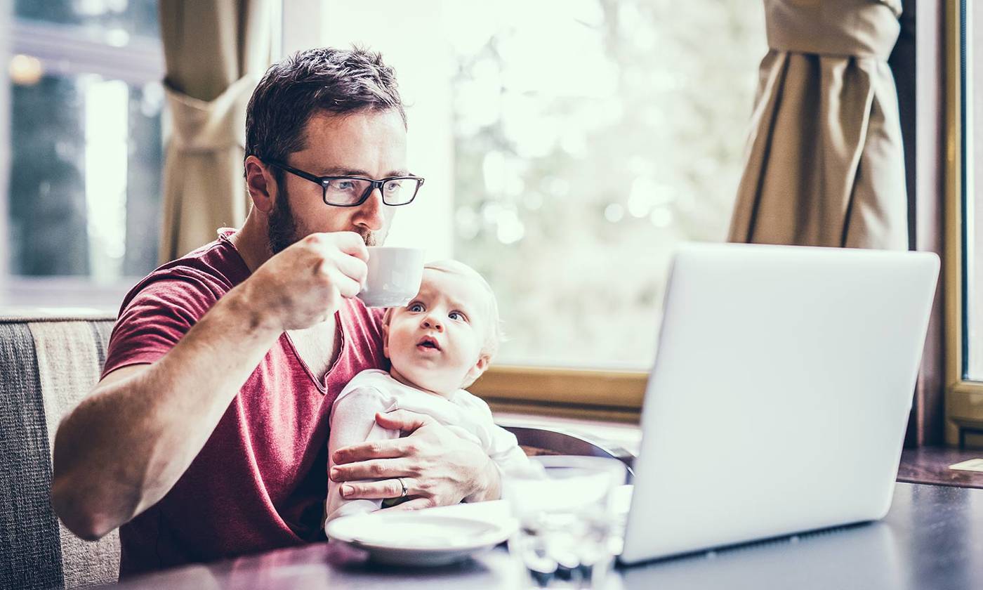 Man with notebook in cafe drinking coffee, holding his son