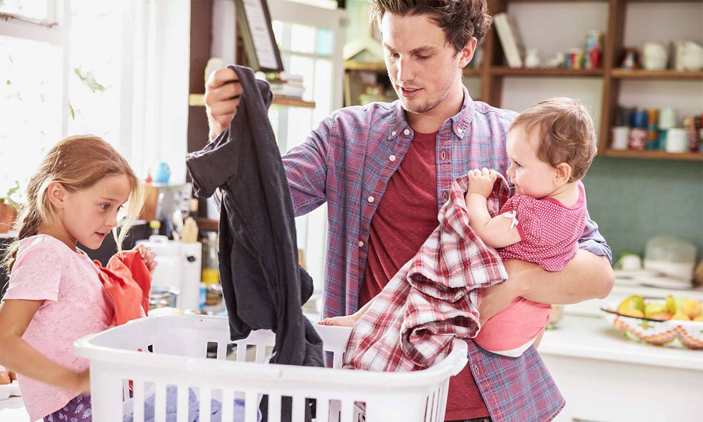 father and child sorting laundry at home
