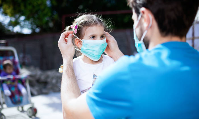 Father applying pollution mask to his daughter.