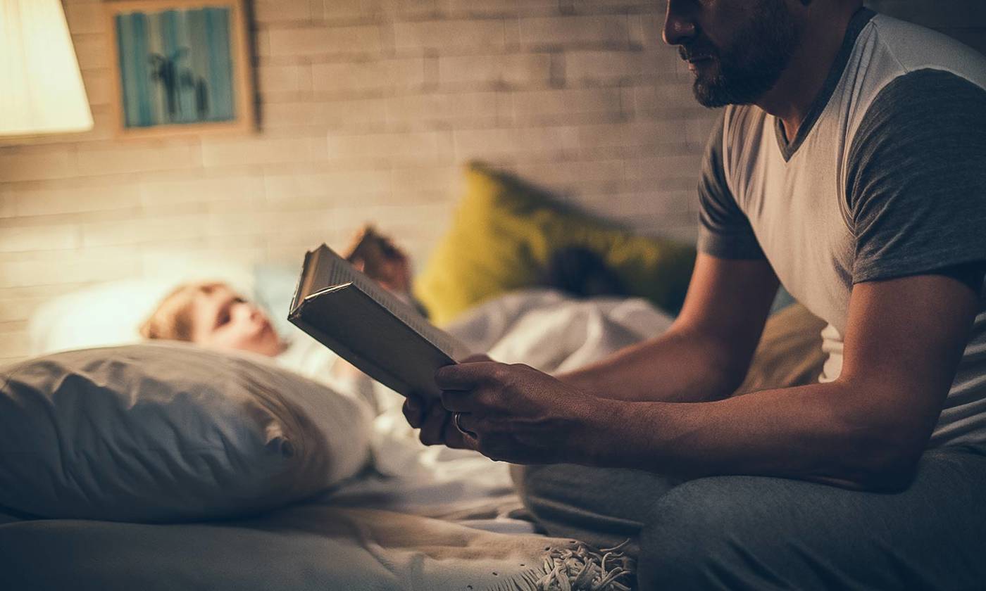 Father reading bedtime story to son