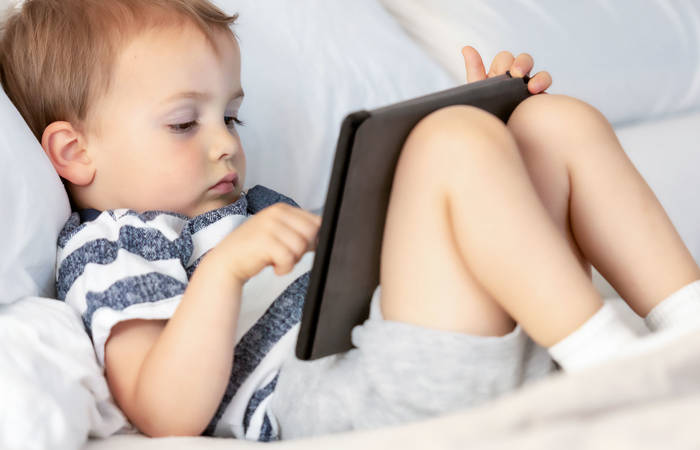 Toddler looking at his electronic tablet