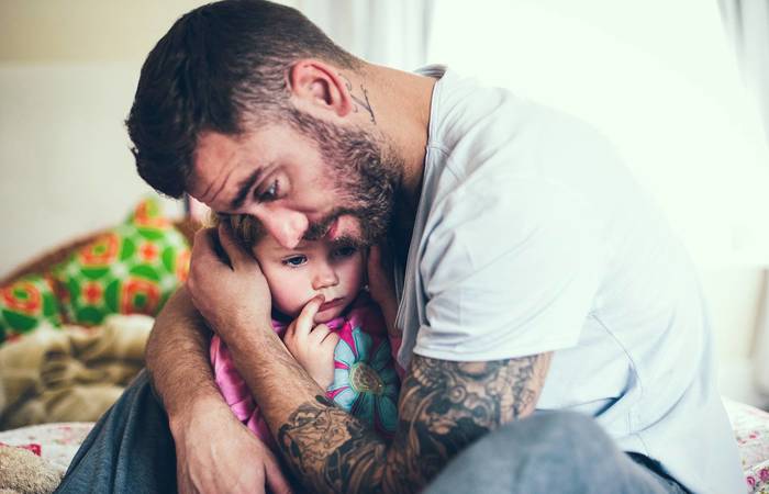 Protective father hugs child