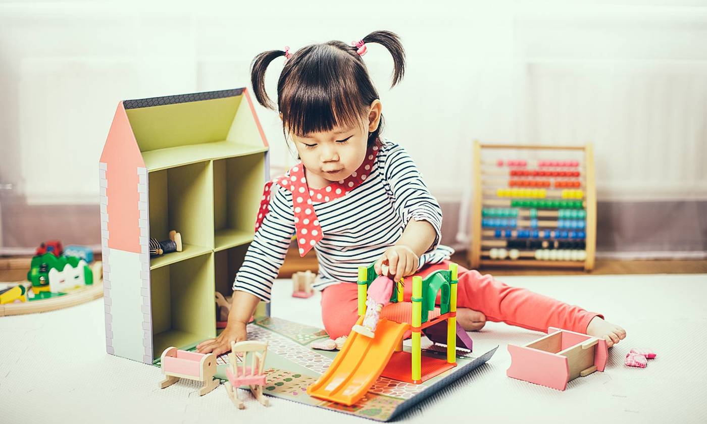 Baby girl playing doll house