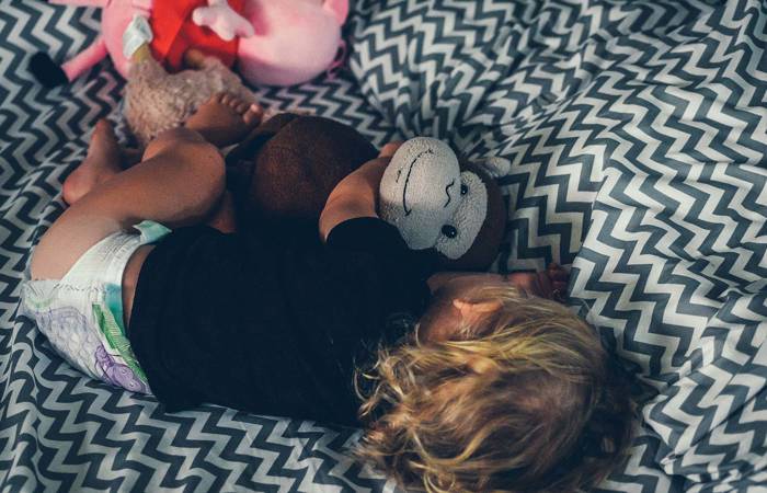 Toddler sleeping with toy monkey