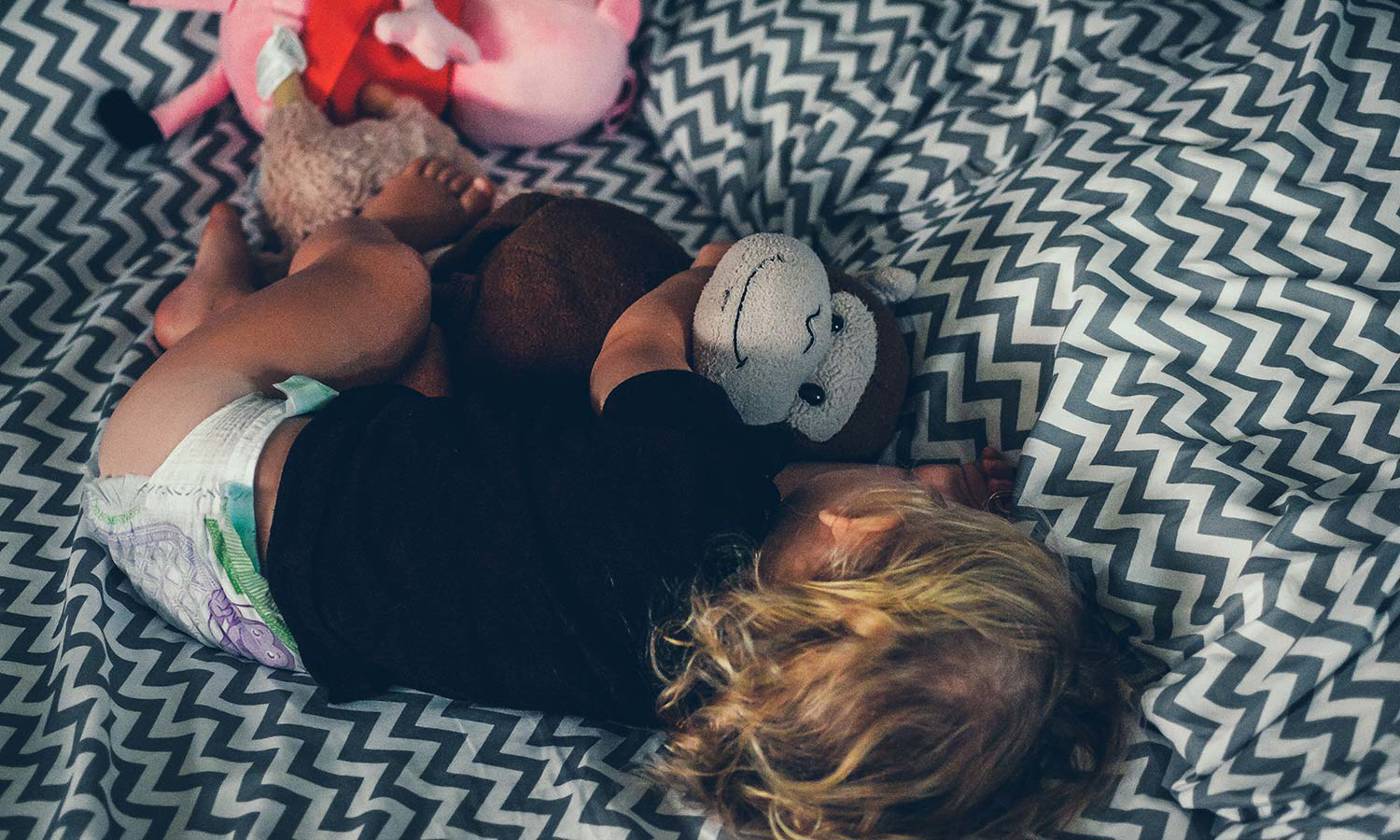 Toddler sleeping with toy monkey