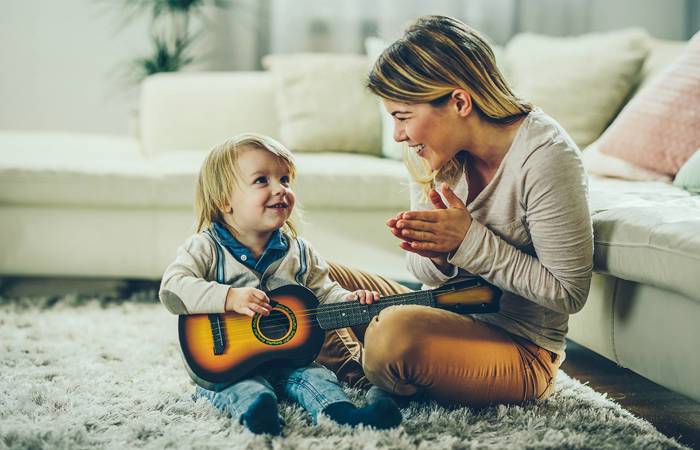 Child being praised for learning the guitar