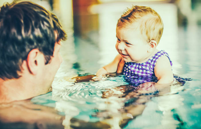 Father swimming with baby girl