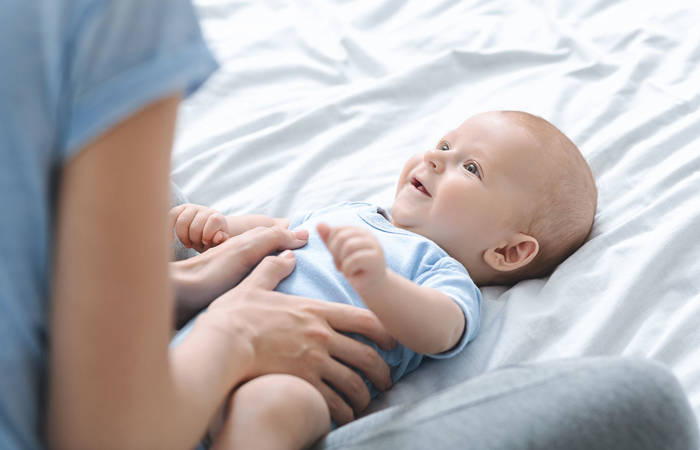 Mother massaging her newborn's son tummy