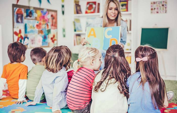 teacher reading a book to children in a classroom