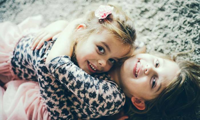 Two girls hugging on the floor