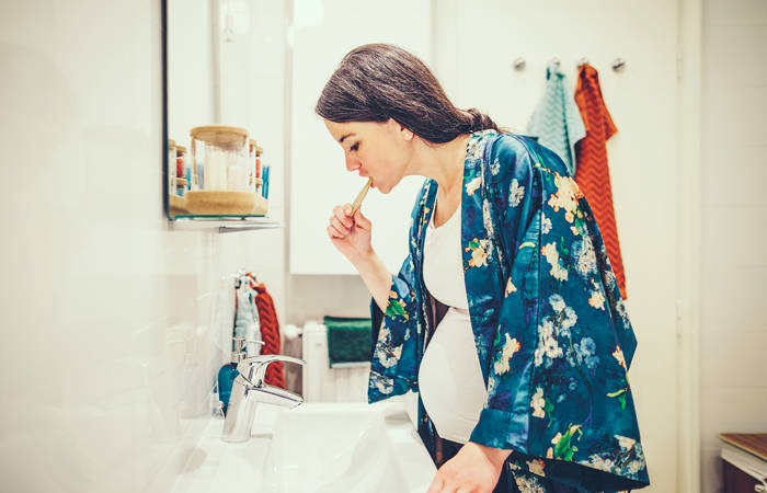 Pregnant woman brushing her teeth